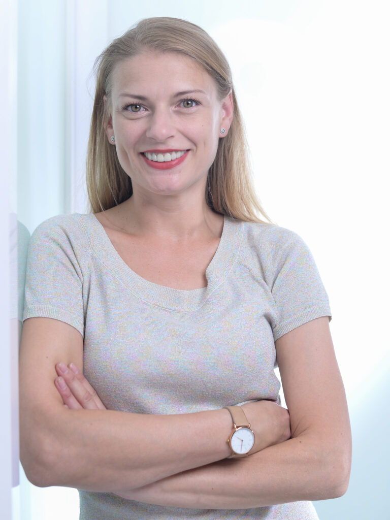 Porträt Elisa Lippold, Gründerin von OrbitEls, mit verschränkten Armen, lächelnd