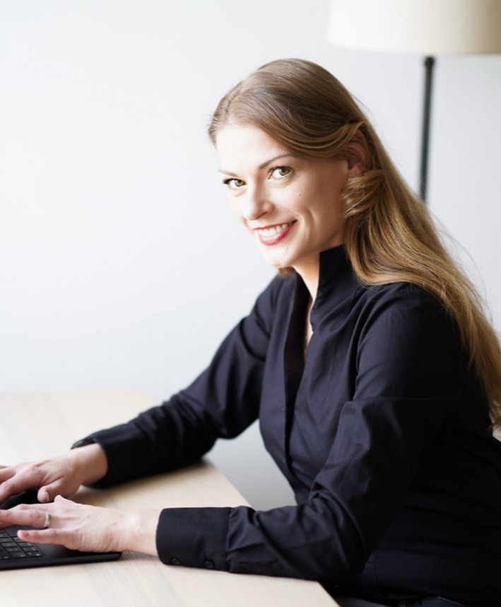 Elisa Lippold, Unternehmensberaterin und Inhaberin von OrbitEls, lächelnd am Laptop